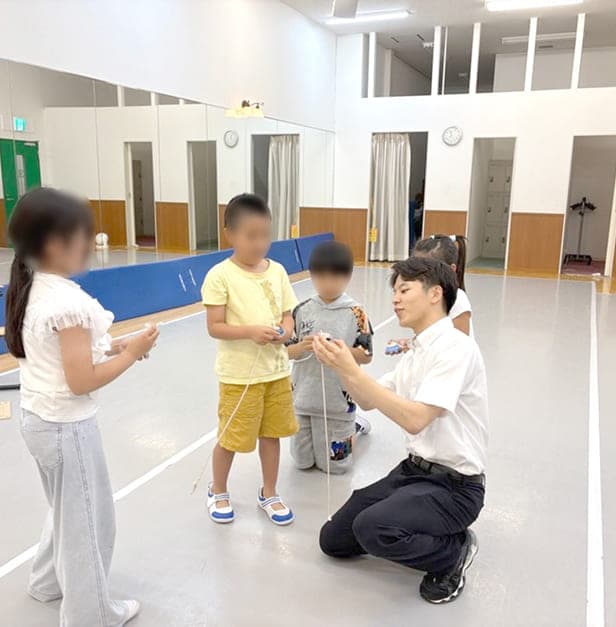 こま教室にてお子さんに指導しています。