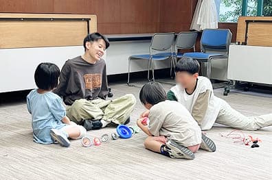 トックがこま教室の生徒とこまについて楽しく話し合っています。